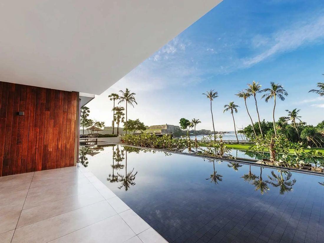 An infinity pool looking out to palms and the sea near Galle