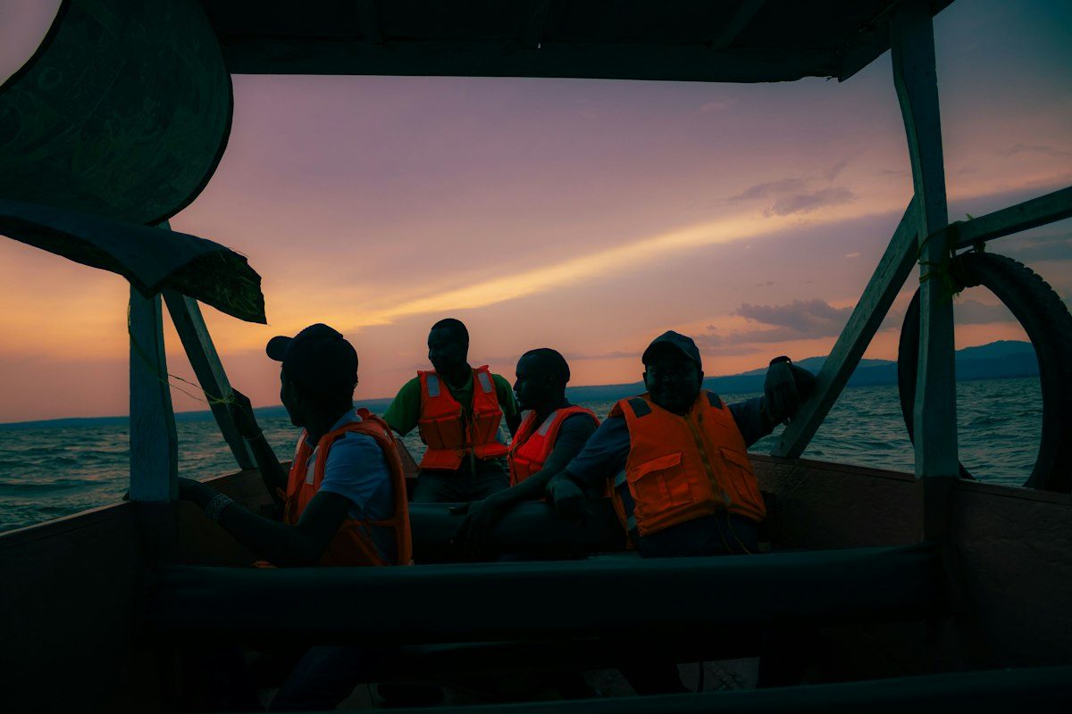 Friends under the canopy of a boat at sunset